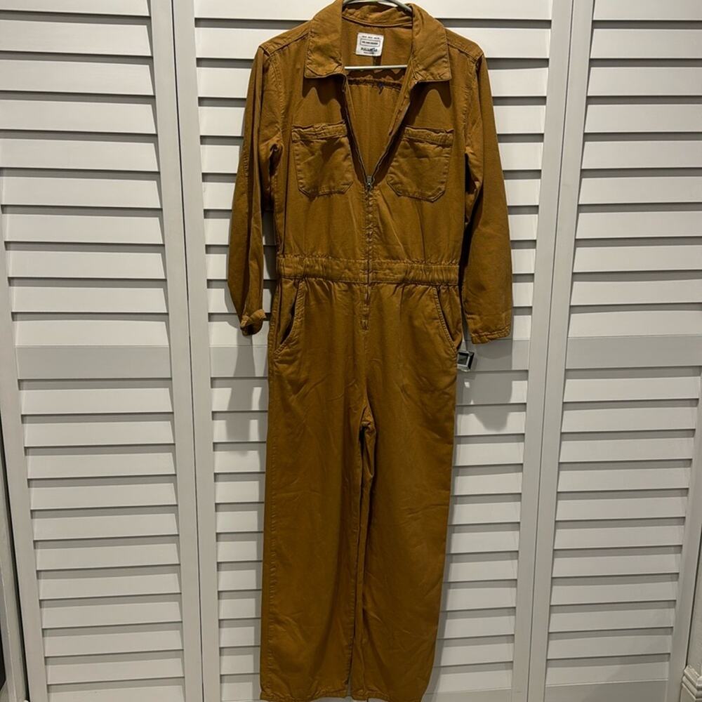 Pull&Bear Pre loved Jumpsuit with front zipper, 3/4 sleeves in a mustard color.